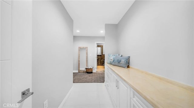 hall featuring baseboards and recessed lighting