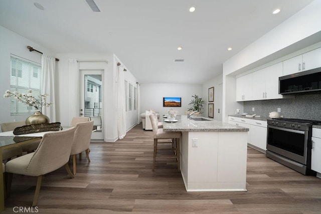 kitchen featuring stainless steel appliances, tasteful backsplash, a sink, and white cabinets