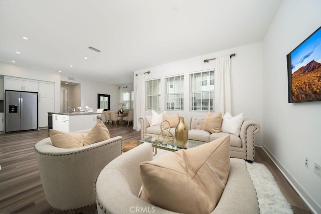 living room featuring recessed lighting, wood finished floors, visible vents, and baseboards