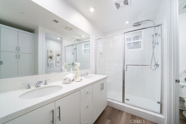 full bathroom featuring visible vents, a sink, a shower stall, and toilet