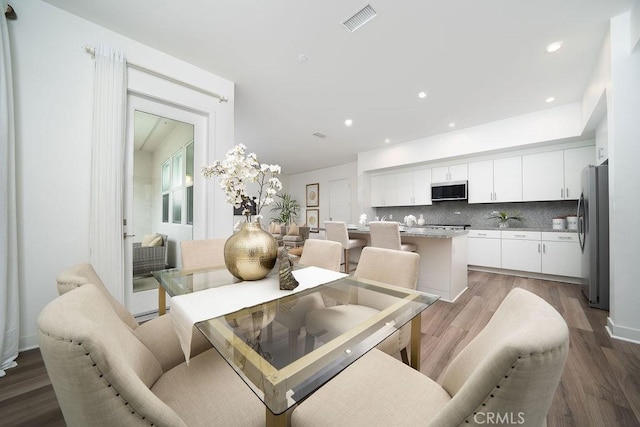 dining area with light wood finished floors, visible vents, and recessed lighting