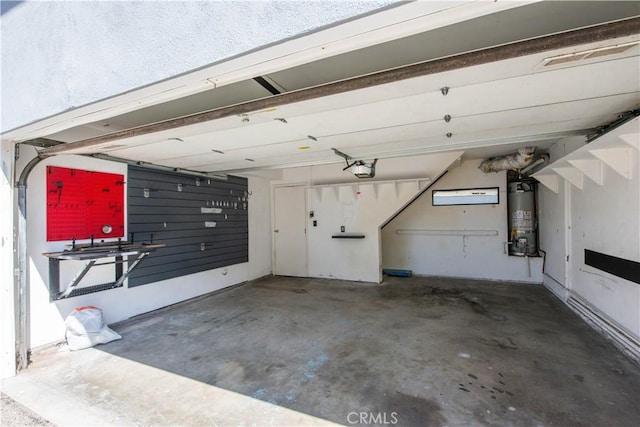 garage with strapped water heater and a garage door opener