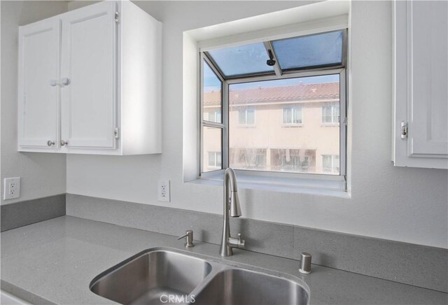 kitchen featuring white cabinets and a sink