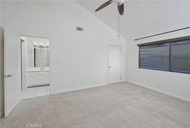 unfurnished bedroom with high vaulted ceiling, light carpet, a sink, visible vents, and ensuite bath