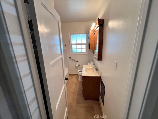 bathroom with visible vents, vanity, toilet, and walk in shower