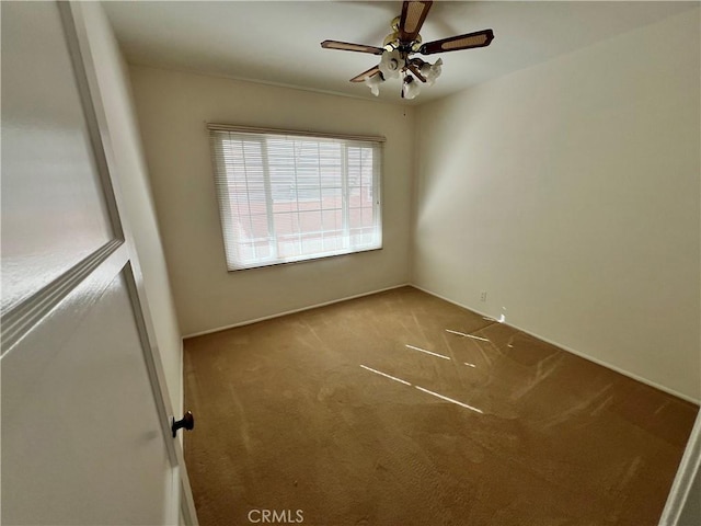 carpeted empty room featuring a ceiling fan