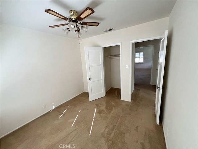 unfurnished bedroom featuring ceiling fan, visible vents, baseboards, a closet, and carpet