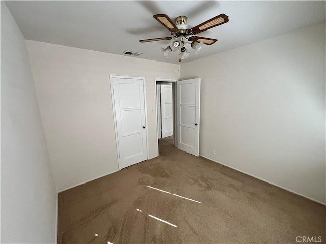 unfurnished bedroom with carpet floors, visible vents, and ceiling fan