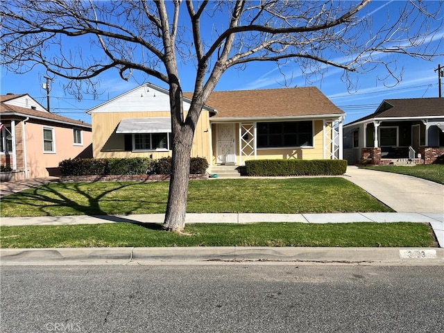 view of front facade featuring a front yard and concrete driveway