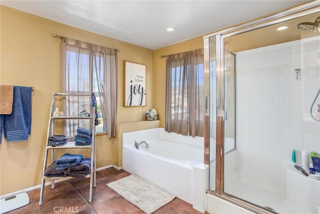 bathroom featuring a garden tub, a shower stall, baseboards, and tile patterned flooring