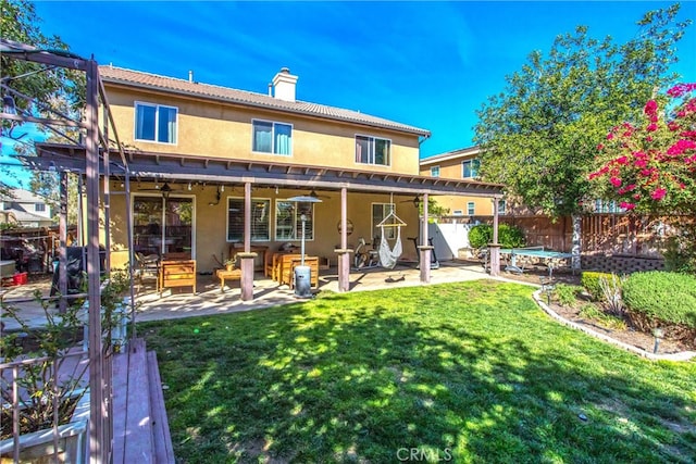 back of property featuring a fenced backyard, a lawn, stucco siding, a chimney, and a patio area