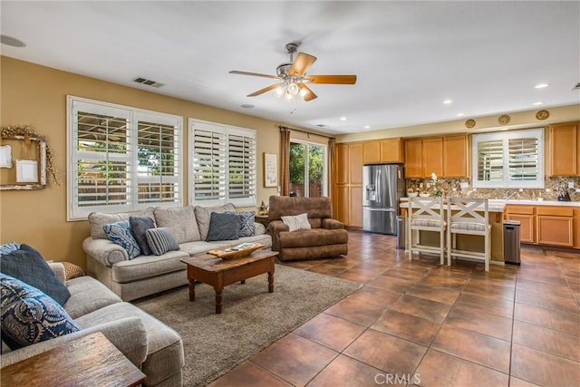 living area featuring dark tile patterned floors, recessed lighting, visible vents, and a ceiling fan