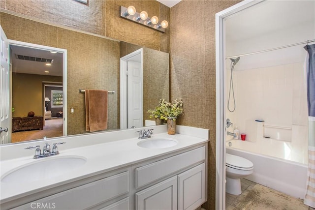 bathroom featuring visible vents, a sink, toilet, and double vanity