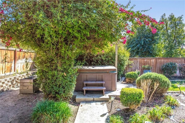 view of yard with a hot tub and a fenced backyard