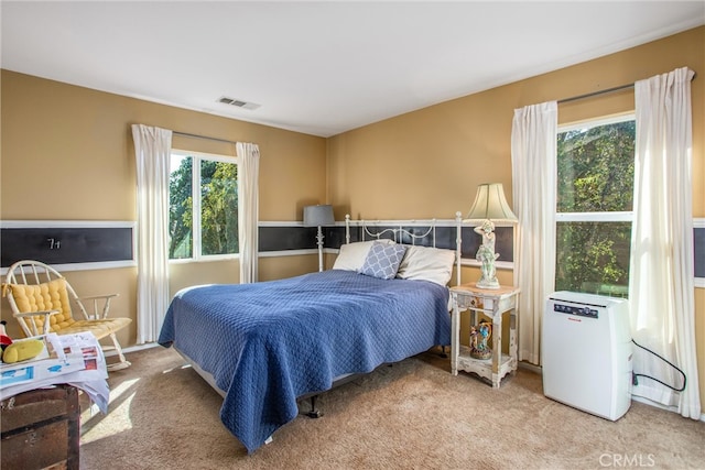 bedroom featuring light colored carpet and visible vents