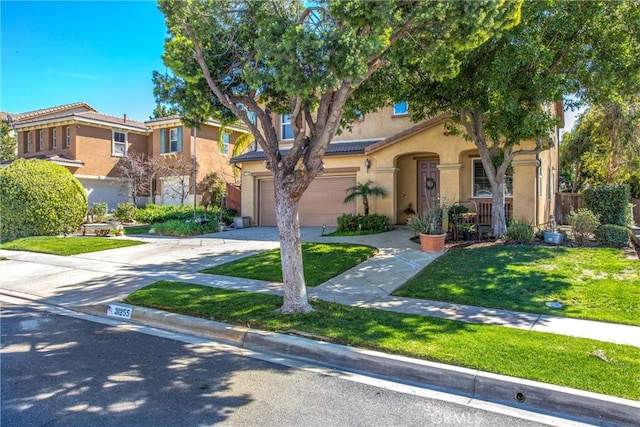 view of front of home with driveway, a front yard, a tile roof, and stucco siding