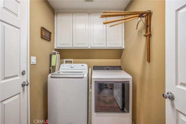 laundry room featuring cabinet space, visible vents, and washing machine and clothes dryer