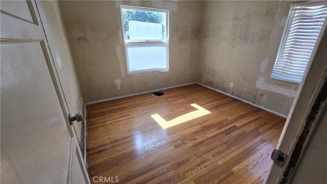 unfurnished bedroom with baseboards and wood finished floors