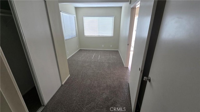 hall with carpet floors and baseboards