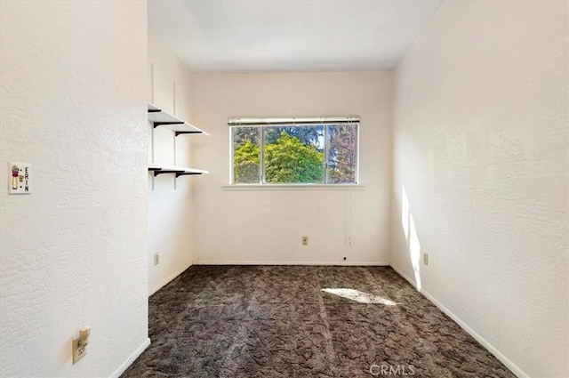 carpeted empty room with a textured wall