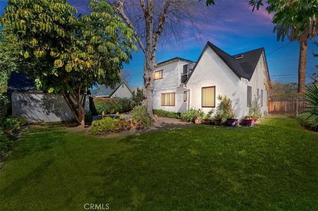 view of front facade with a front yard, fence, and stucco siding