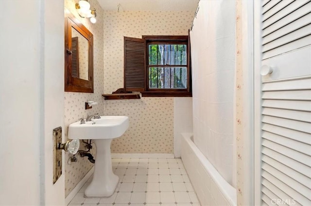 full bathroom featuring wallpapered walls, baseboards, and tile patterned floors