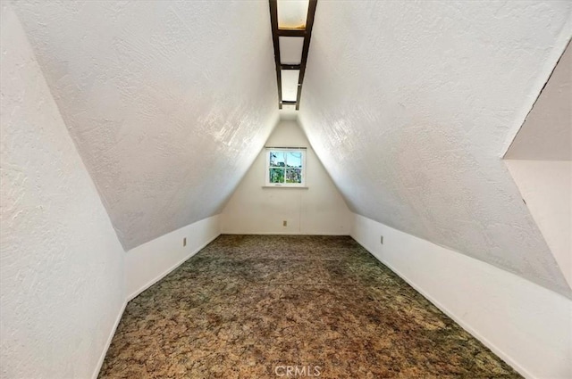 bonus room with carpet floors, a textured wall, vaulted ceiling, and a textured ceiling