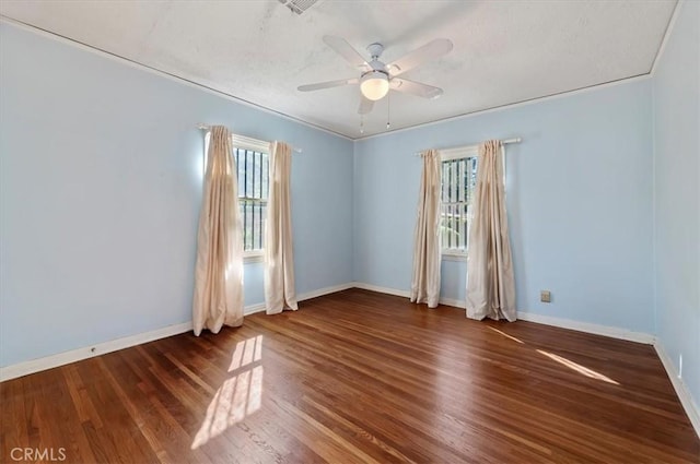 empty room with plenty of natural light, baseboards, and wood finished floors