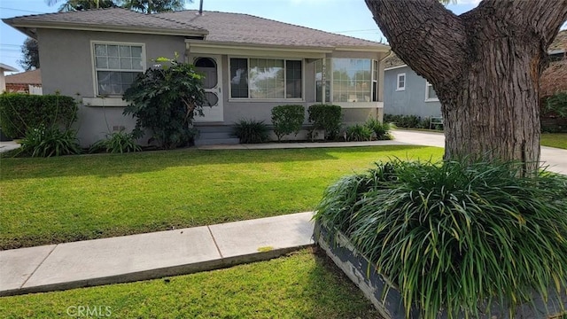 view of front of house with a front yard and stucco siding