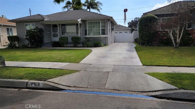 bungalow featuring stucco siding, a gate, fence, a garage, and a front lawn