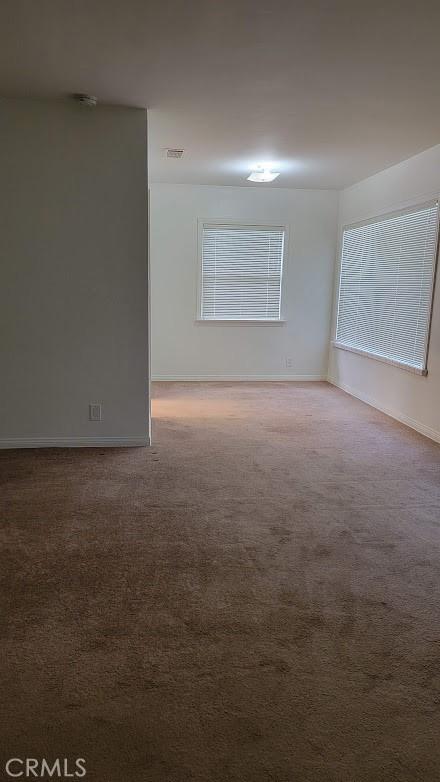 carpeted empty room with baseboards