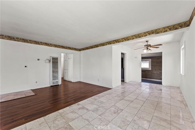 unfurnished room featuring ceiling fan, baseboards, and wood finished floors