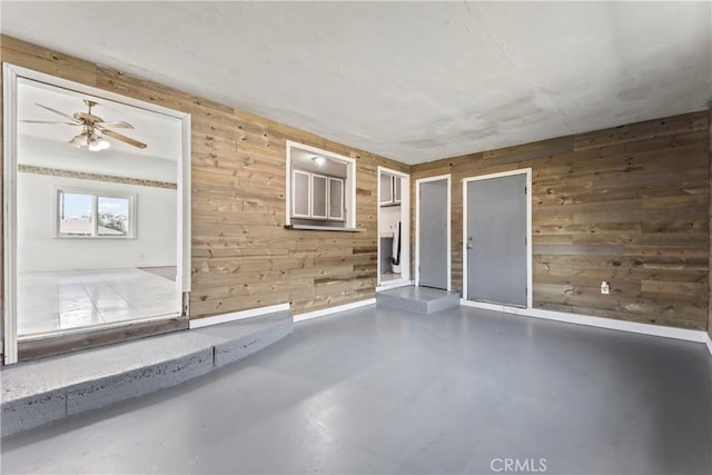 empty room with concrete floors and wooden walls