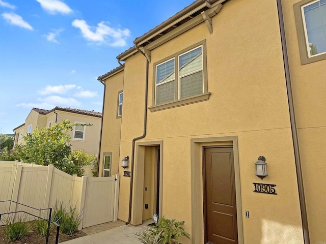 rear view of property with fence and stucco siding