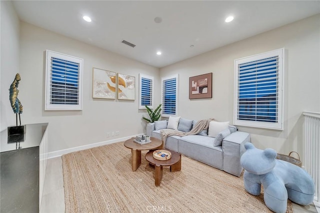 living area featuring baseboards, visible vents, and recessed lighting