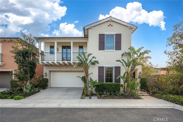 view of front of property with a garage, a balcony, concrete driveway, and stucco siding