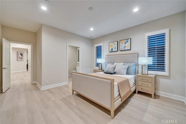 bedroom featuring baseboards, ensuite bath, light wood-style flooring, and recessed lighting