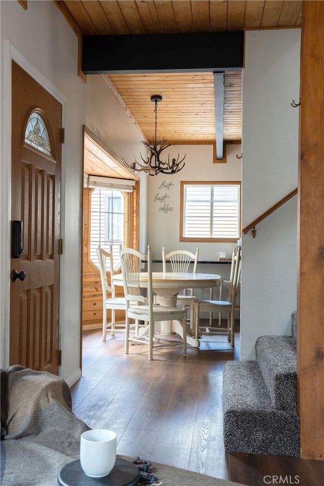 dining room featuring wooden ceiling, wood-type flooring, stairway, and beam ceiling