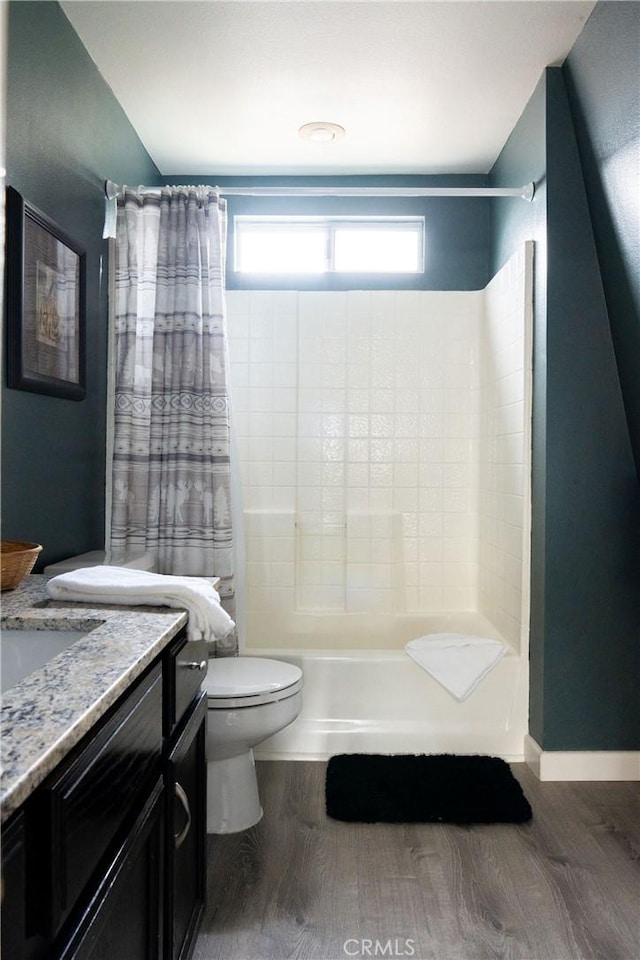 full bathroom featuring vanity, wood finished floors, toilet, and baseboards