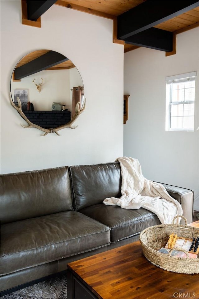 living area featuring beamed ceiling, wood finished floors, and wood ceiling