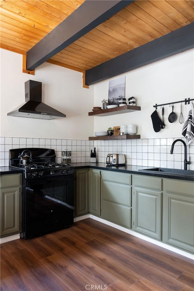 kitchen featuring black gas range, a sink, wall chimney exhaust hood, tasteful backsplash, and dark countertops