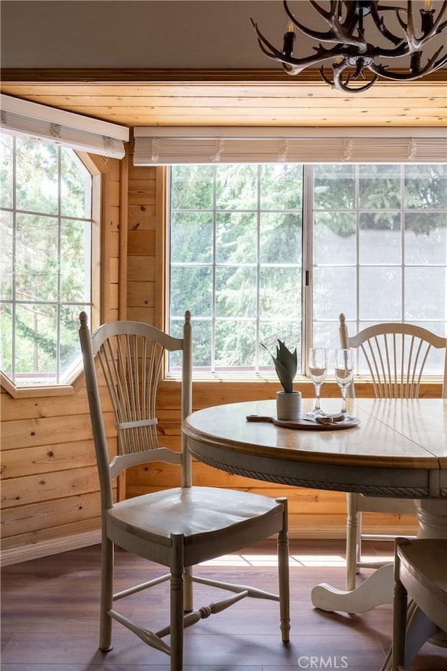 interior space featuring wood walls, a notable chandelier, and wood finished floors