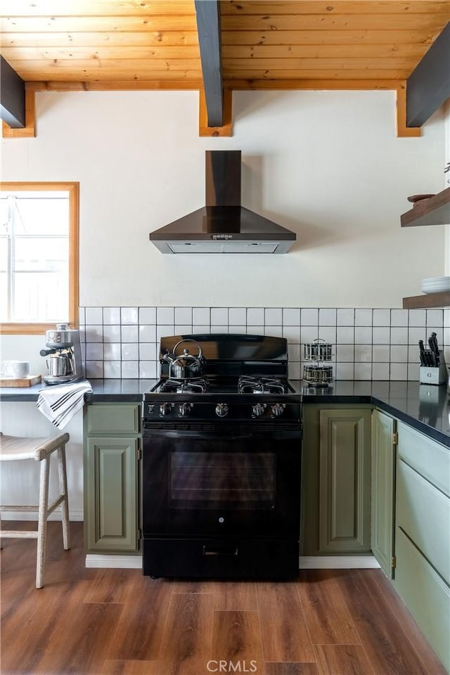 kitchen with tasteful backsplash, gas stove, dark countertops, and wall chimney exhaust hood