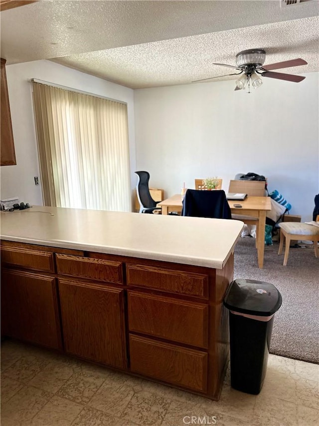 kitchen featuring visible vents, light countertops, ceiling fan, and a textured ceiling