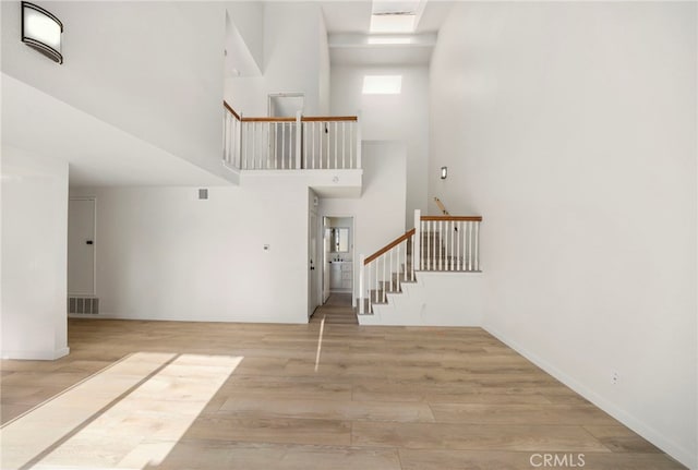 3635 Sierra Cir Unit 22, West Covina, CA 91792 - staircase featuring a towering ceiling, baseboards, visible vents, and wood finished floors
