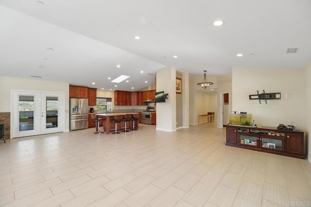 living room featuring recessed lighting, visible vents, a notable chandelier, and vaulted ceiling