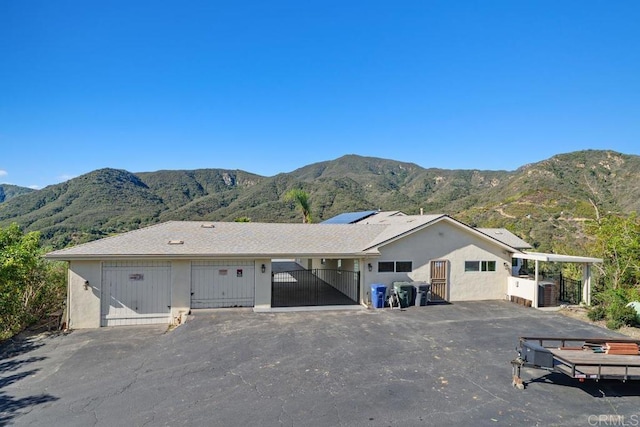 single story home featuring a gate, fence, a mountain view, and stucco siding