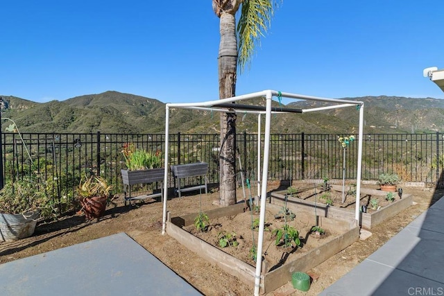 view of yard with a garden, a mountain view, and fence