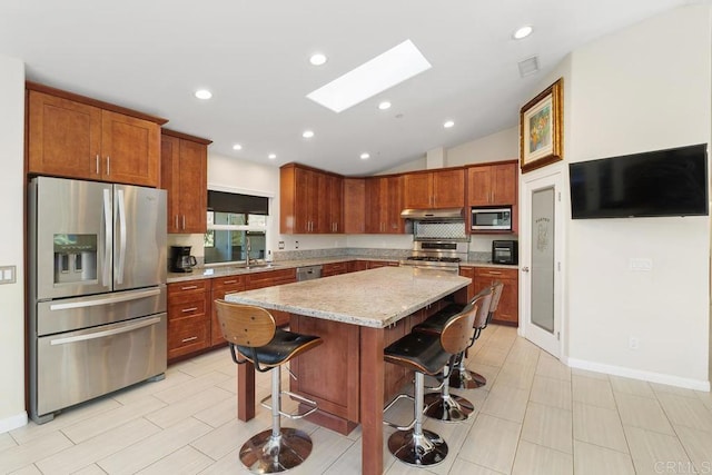 39255 De Luz Rd, Fallbrook, CA 92028 - kitchen featuring appliances with stainless steel finishes, a skylight, a sink, vaulted ceiling, and a kitchen breakfast bar