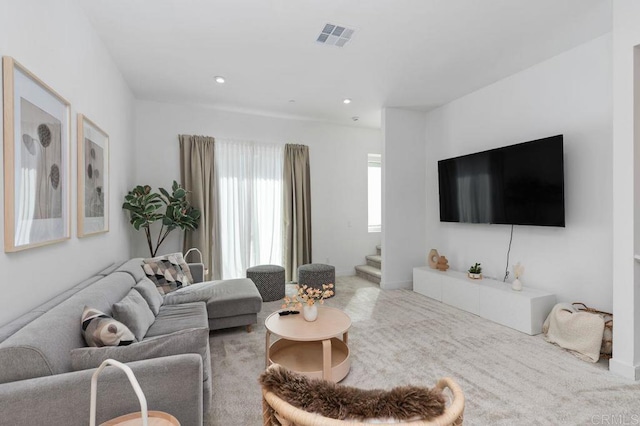 carpeted living room featuring visible vents, stairway, and recessed lighting